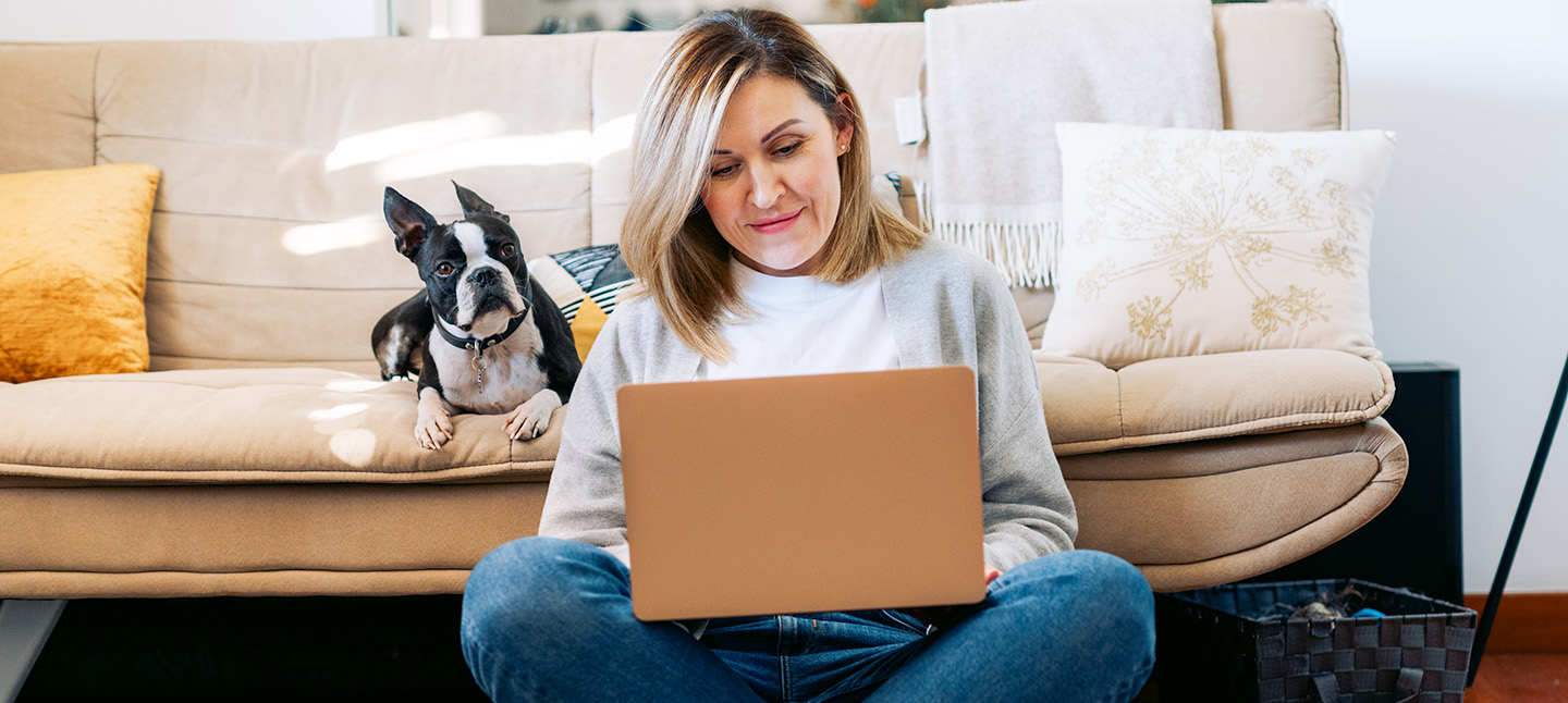 Women sitting on her living room floor on her laptop