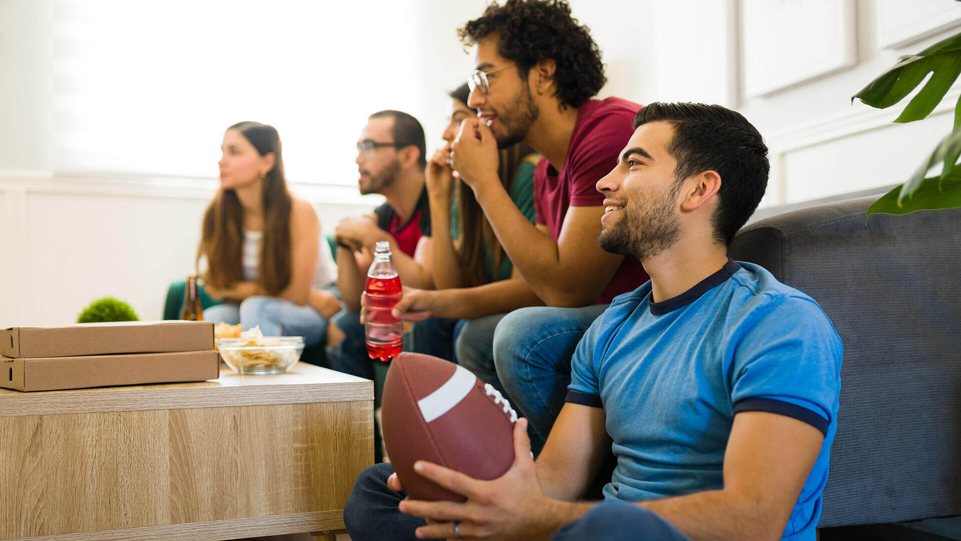 A group of friends watching a football game at one of their homes