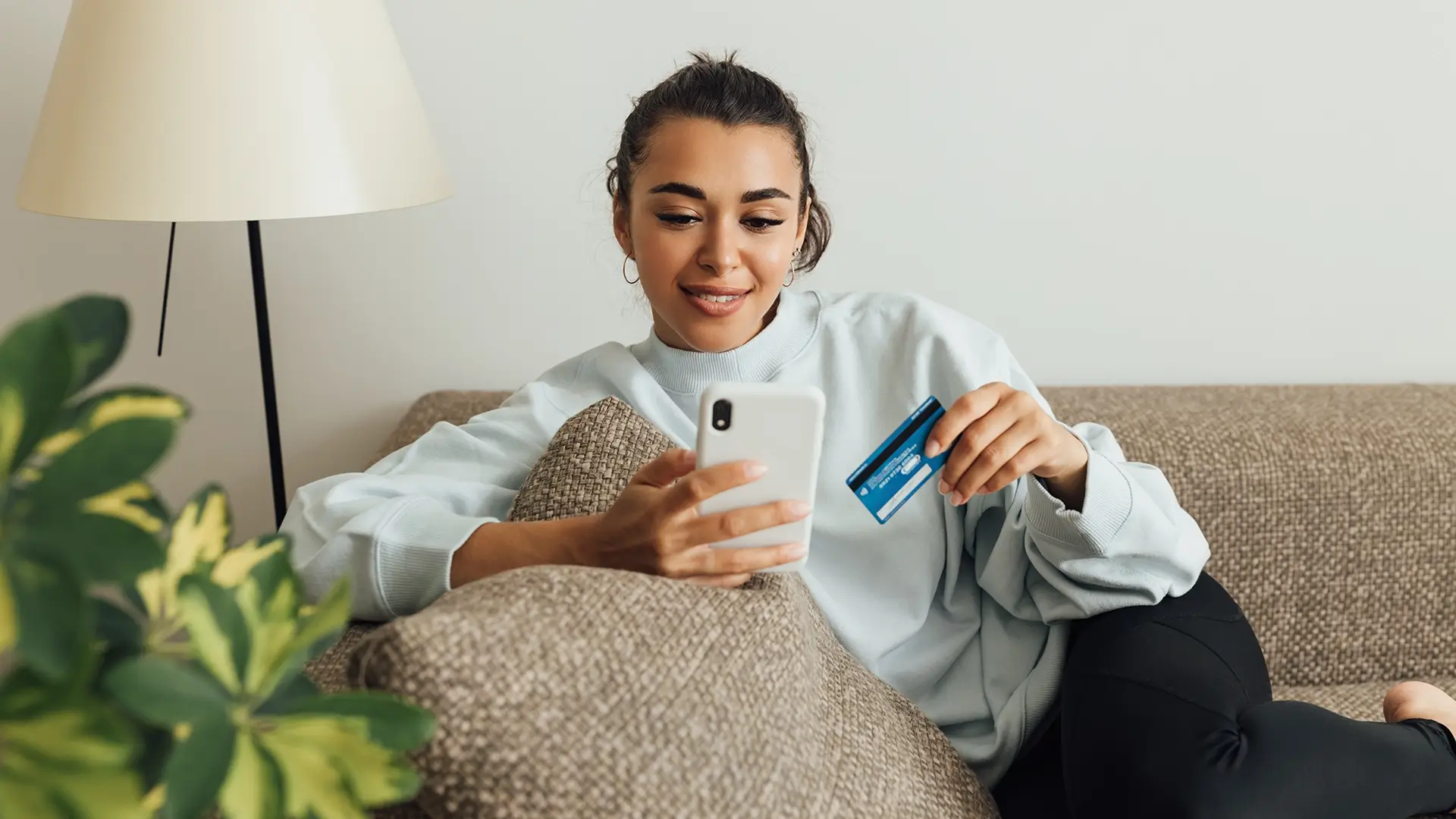 A young woman on her laptop using her credit card to pay