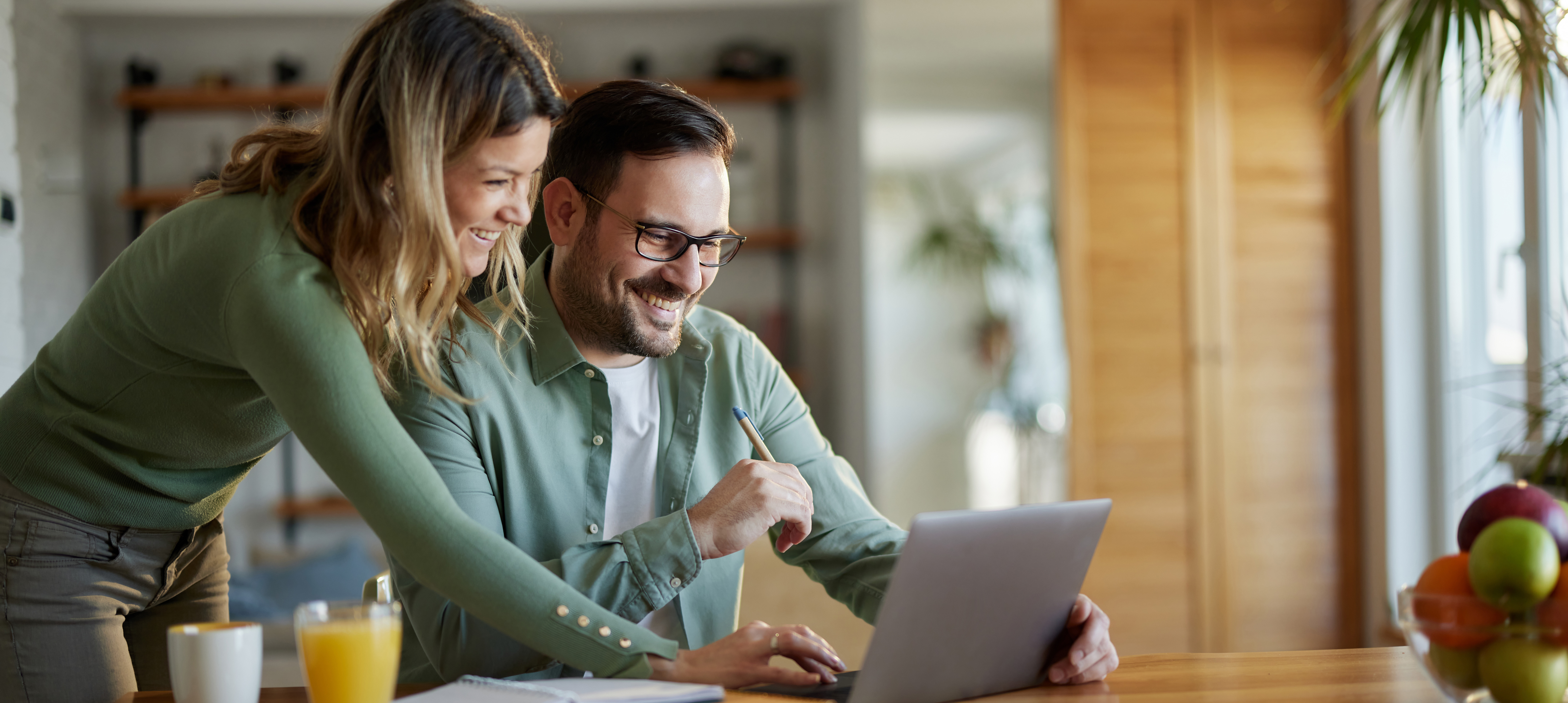 Happy business couple working on laptop at home office