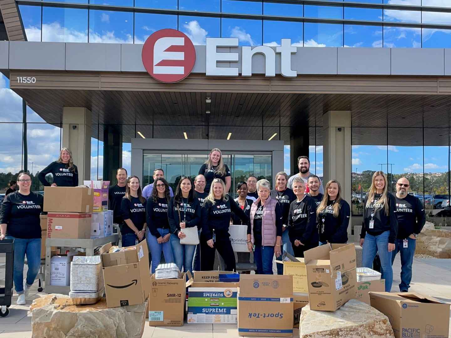 Image of Ent Credit Union employees in front of Ent Credit Union Headquarters volunteering with boxes for Care and Share.
